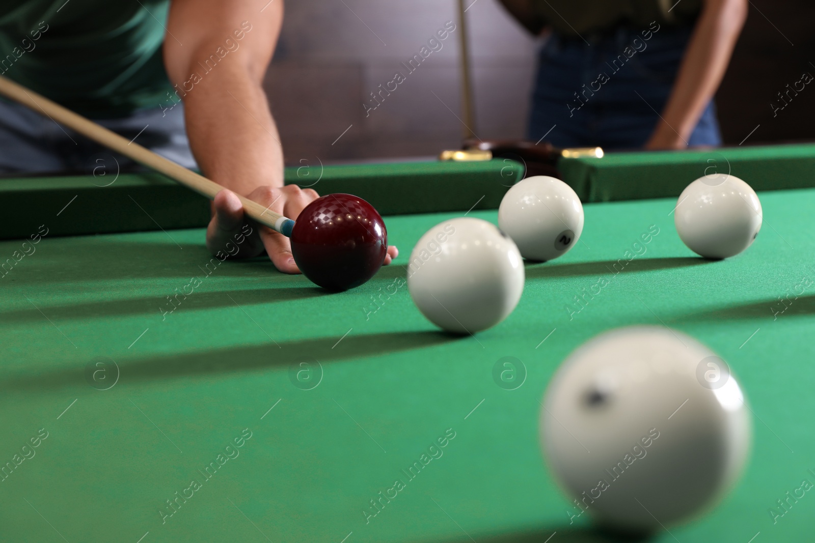 Photo of Young man and woman playing billiard indoors, closeup