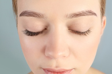 Photo of Young woman with beautiful eyelashes on gray background, closeup. Before and after extension procedure