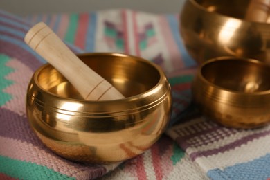 Photo of Tibetan singing bowls with mallet on colorful fabric