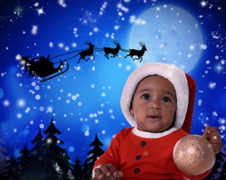 Image of Cute African American baby and Santa Claus flying in his sleigh against moon sky on background. Christmas celebration
