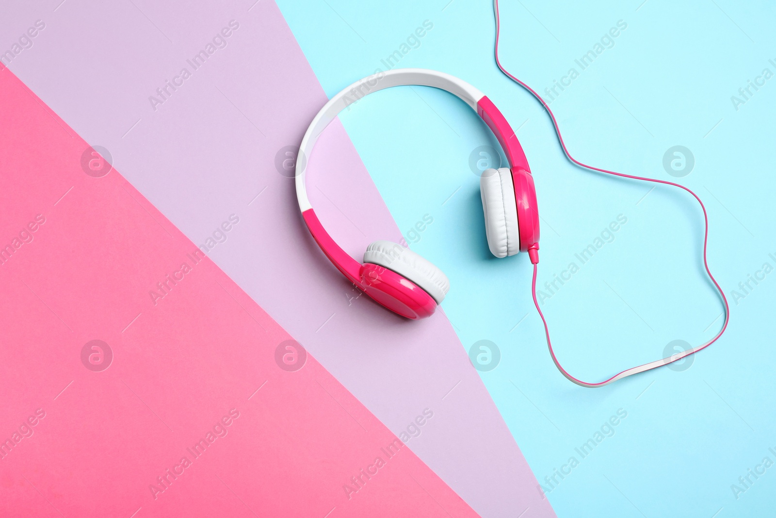 Photo of Stylish headphones on color background, top view. Space for text