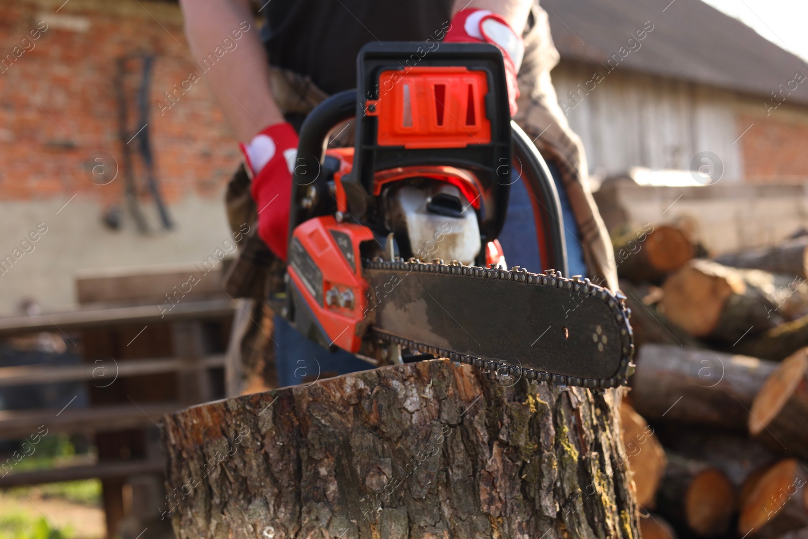 Photo of Man sawing wooden log outdoors, closeup view