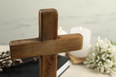 Wooden Christian cross on table, closeup. Space for text