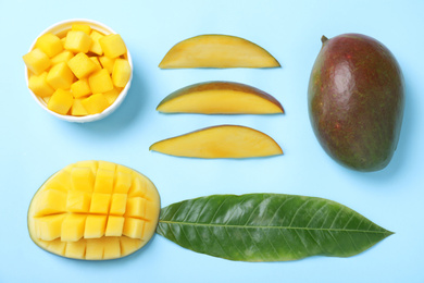 Flat lay composition with fresh ripe mango on light blue background