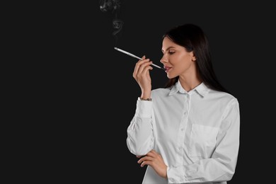 Woman using long cigarette holder for smoking on black background, space for text