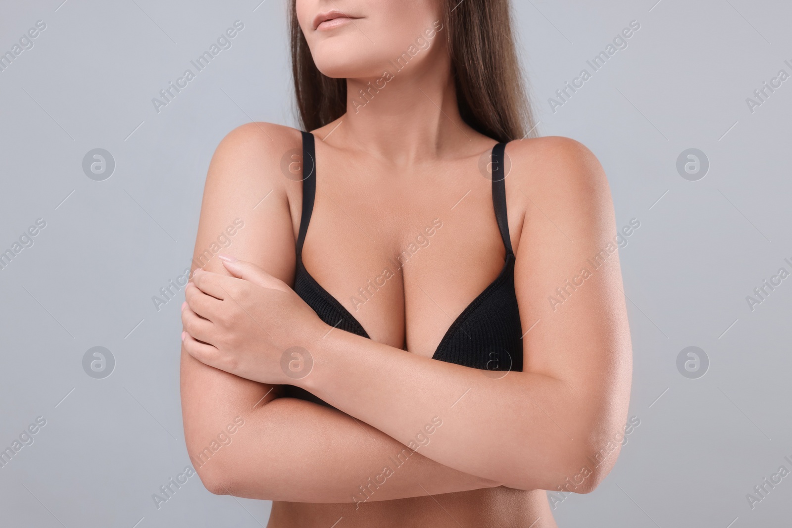 Photo of Woman with beautiful breast on light grey background, closeup. Space for text