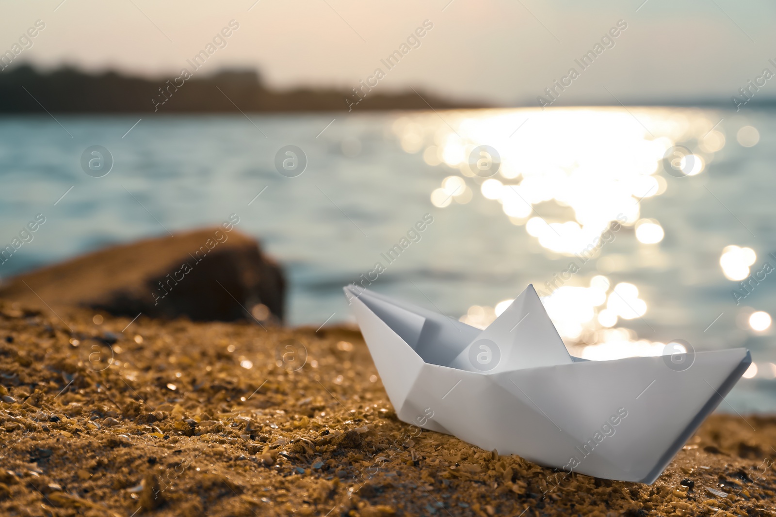 Photo of White paper boat near river on sunny day, space for text