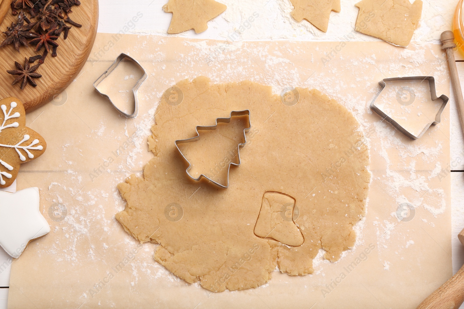 Photo of Making Christmas cookies. Raw dough, anise stars and cutters on white table, flat lay