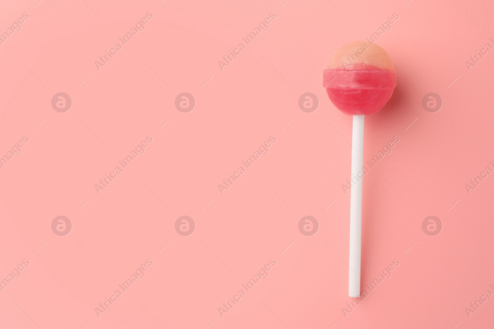 Photo of One tasty lollipop on pink background, top view. Space for text