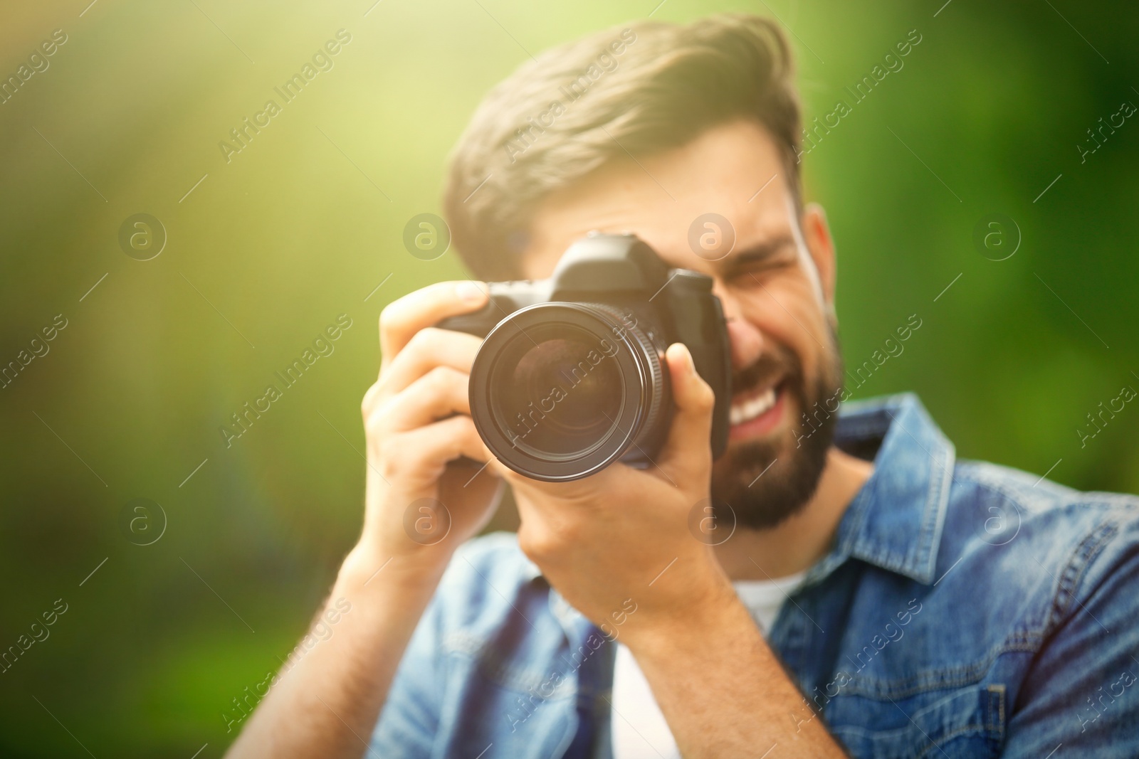 Image of Photographer taking photo with professional camera in park