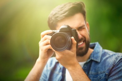 Image of Photographer taking photo with professional camera in park