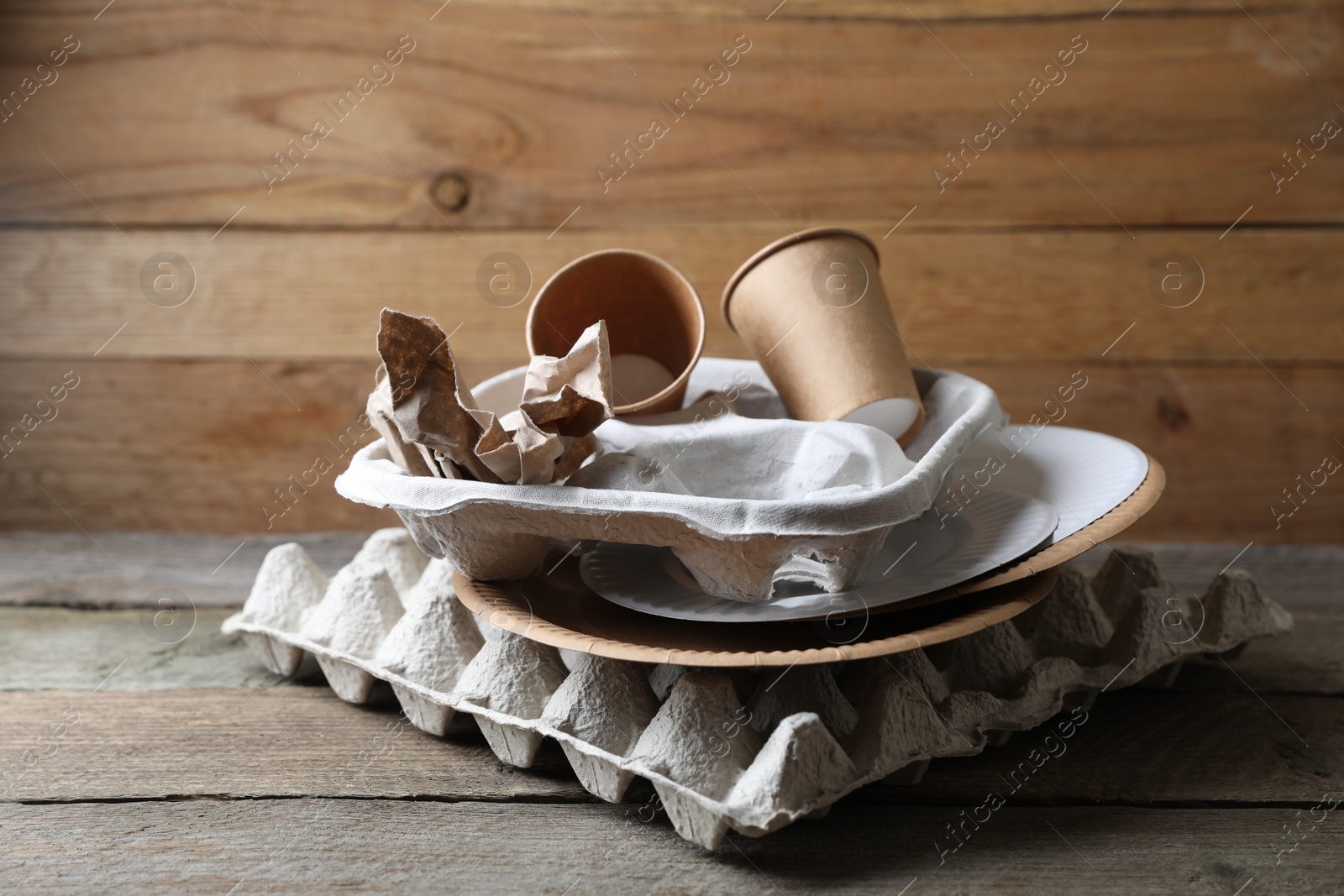 Photo of Different waste paper on wooden table near wall