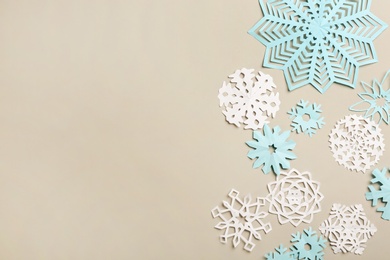 Many paper snowflakes on light grey background, flat lay. Space for text