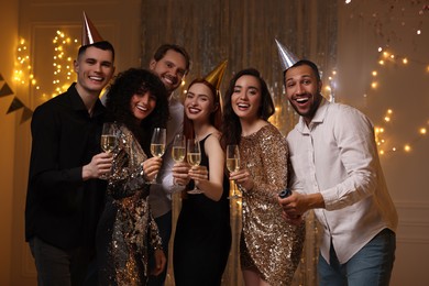 Photo of Happy friends with glassessparkling wine celebrating birthday indoors
