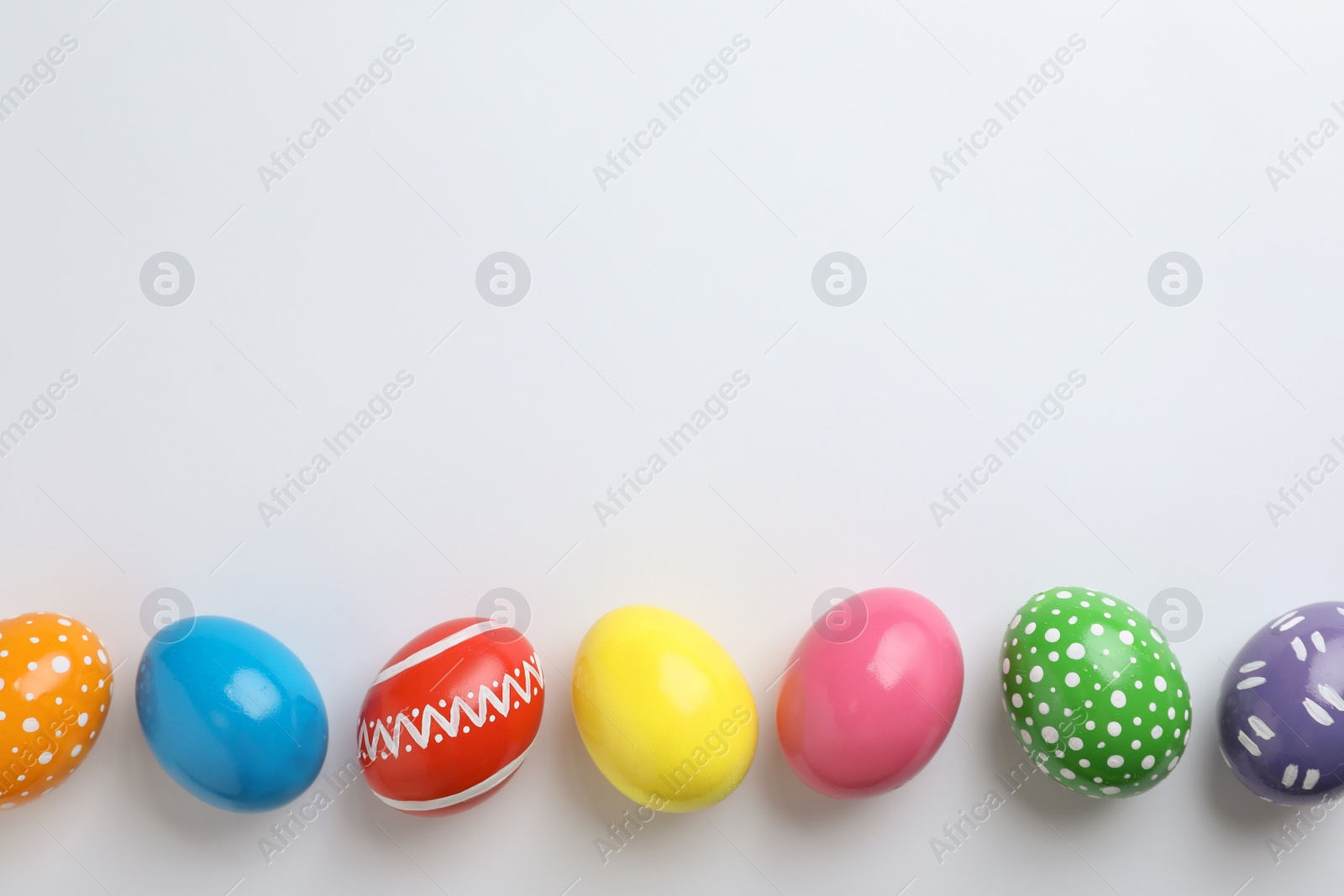 Photo of Decorated Easter eggs and space for text on white background, top view