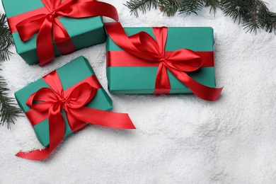 Photo of Flat lay composition with gift boxes, Christmas tree branches and artificial snow