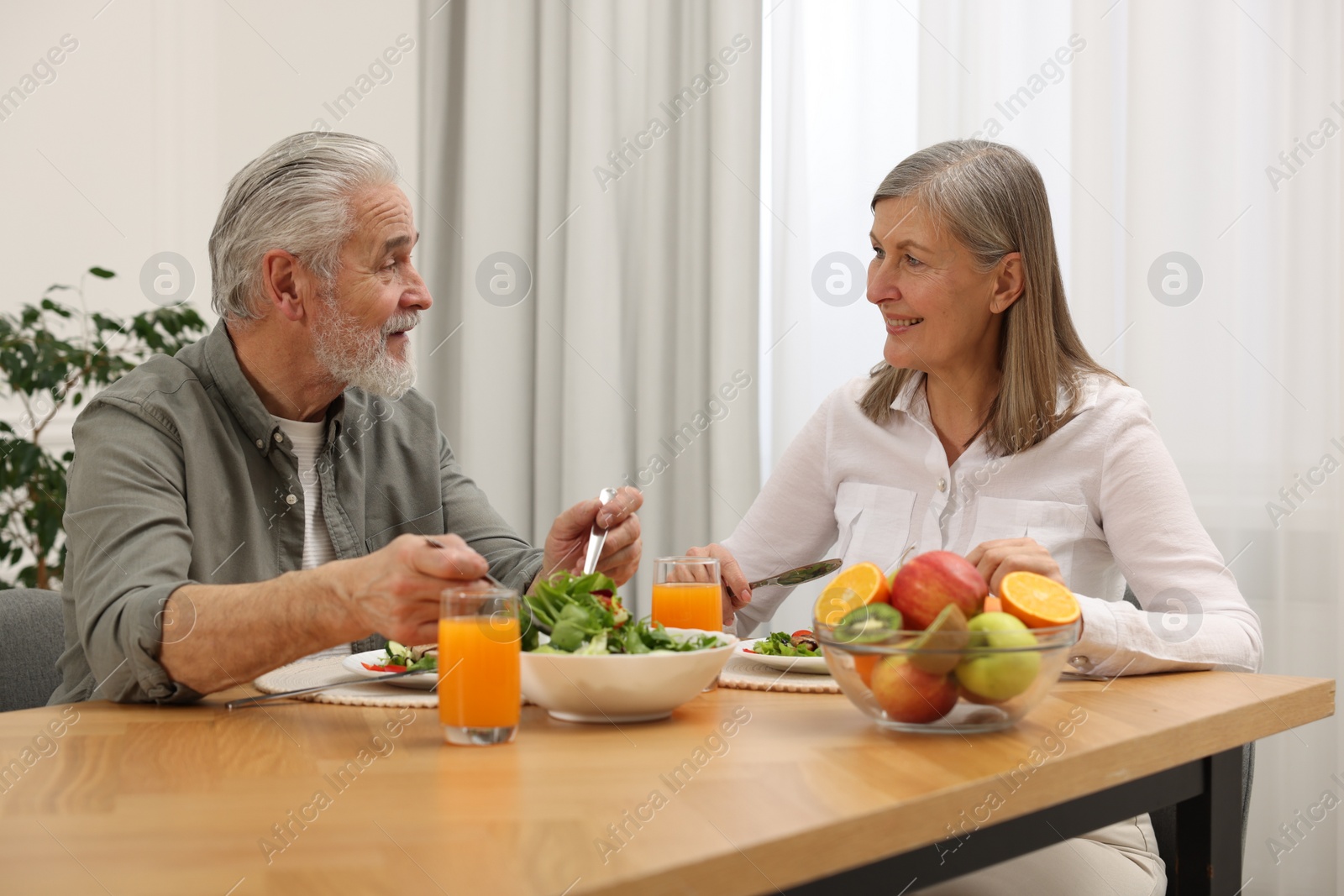 Photo of Happy senior couple having dinner at home