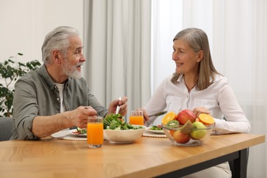 Happy senior couple having dinner at home