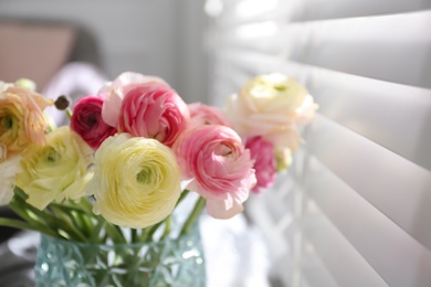 Photo of Beautiful ranunculus flowers in vase near window indoors, closeup