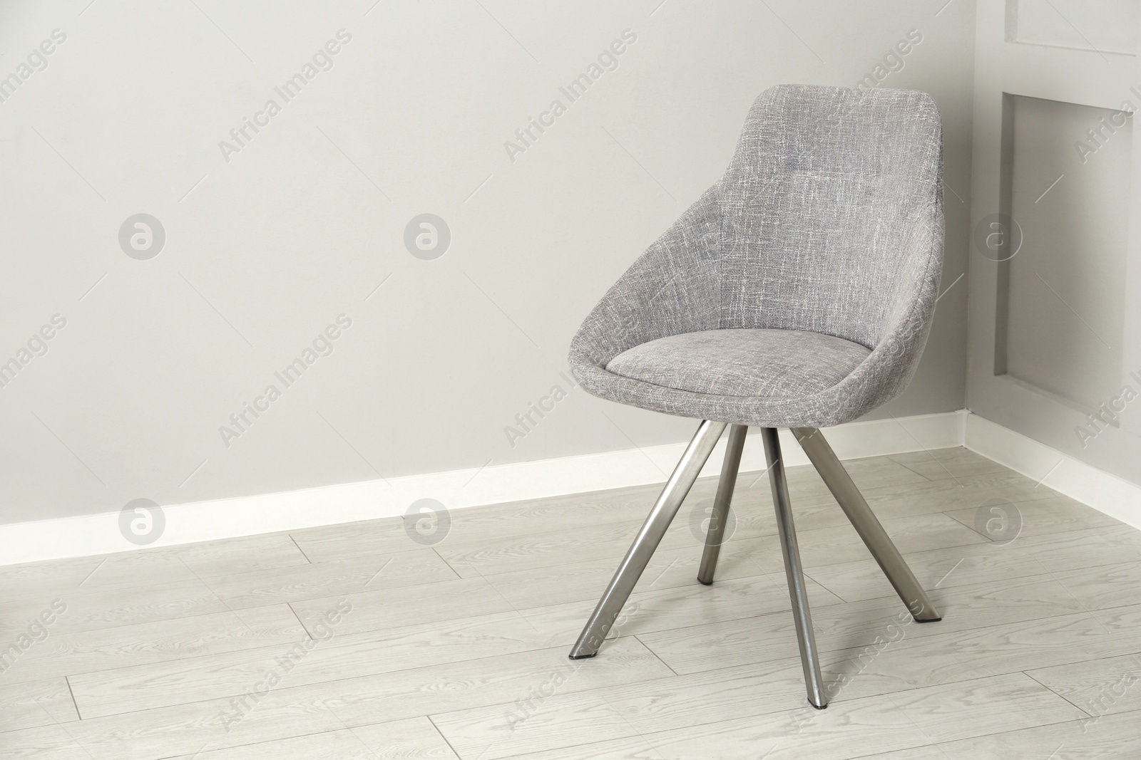 Photo of Stylish chair near light wall in room. Space for text