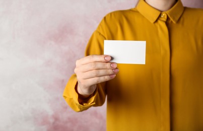 Photo of Woman holding blank business card on pink background, closeup. Mockup for design