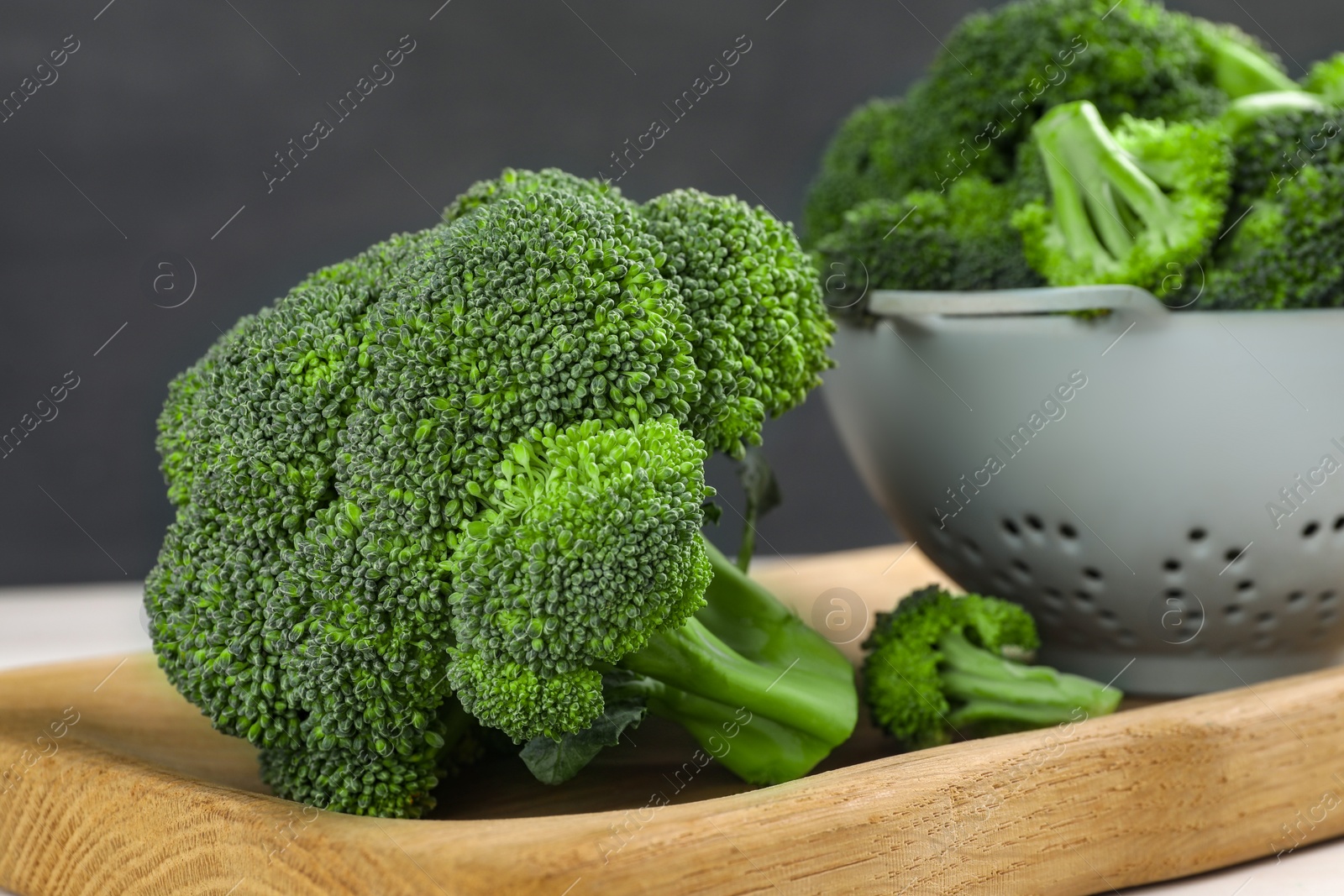 Photo of Fresh raw broccoli on wooden board, closeup