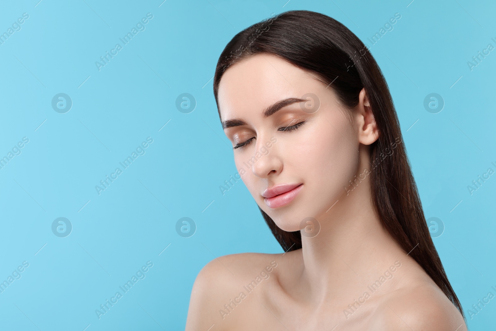 Photo of Portrait of beautiful young woman on light blue background. Space for text