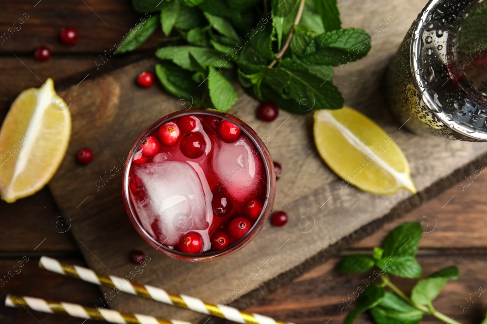 Photo of Tasty refreshing cranberry cocktail and fresh ingredients on wooden table, flat lay