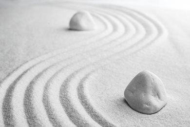 Photo of White stones on sand with pattern. Zen, meditation, harmony