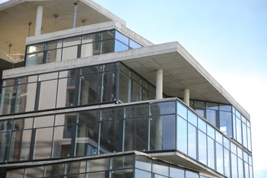 Photo of Modern building with big windows against blue sky outdoors