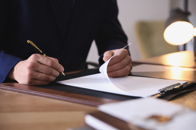 Male lawyer working at table in office, closeup