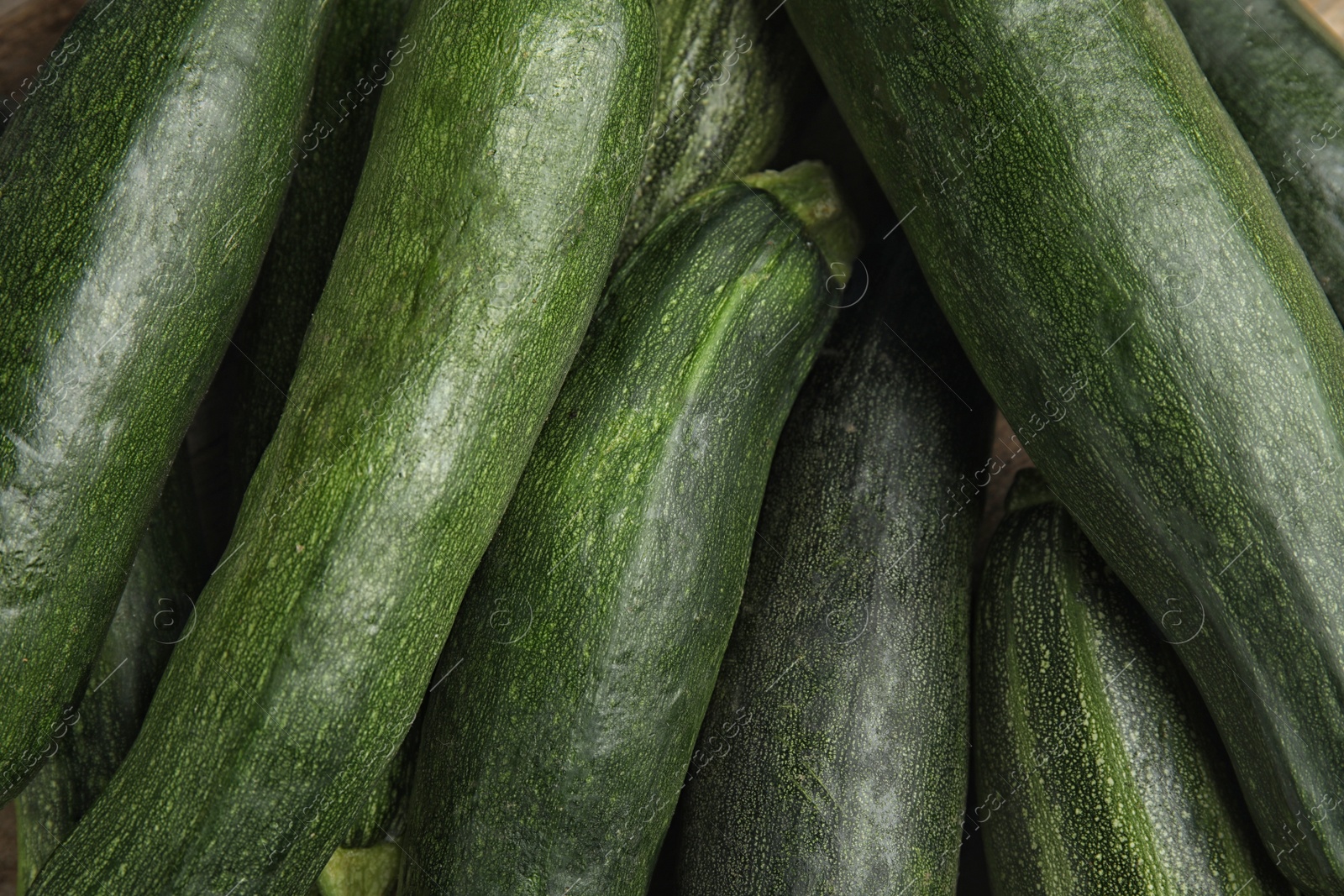 Photo of Top view of fresh ripe zucchini as background, closeup