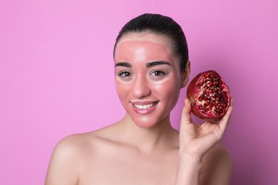 Photo of Woman with pomegranate face mask and fresh fruit on pink background