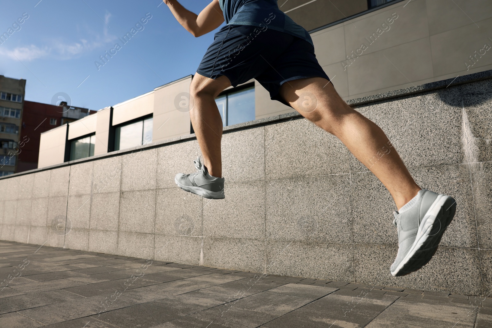 Photo of Man running near building outdoors, closeup. Space for text