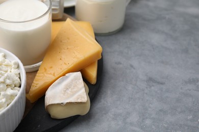 Different fresh dairy products on grey table, space for text