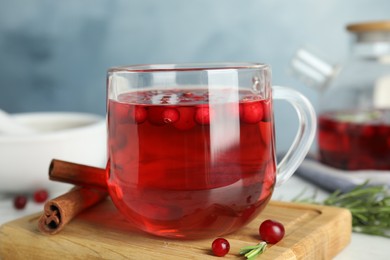 Photo of Tasty hot cranberry tea and fresh ingredients on white table