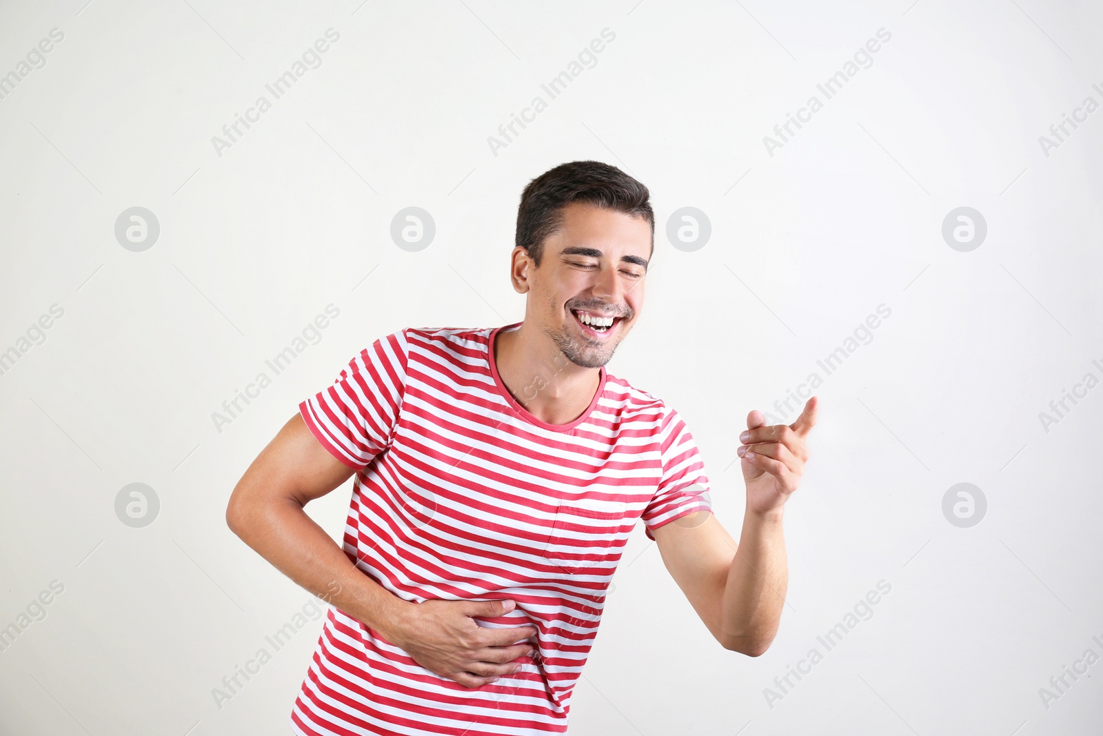 Photo of Portrait of handsome young man laughing on white background