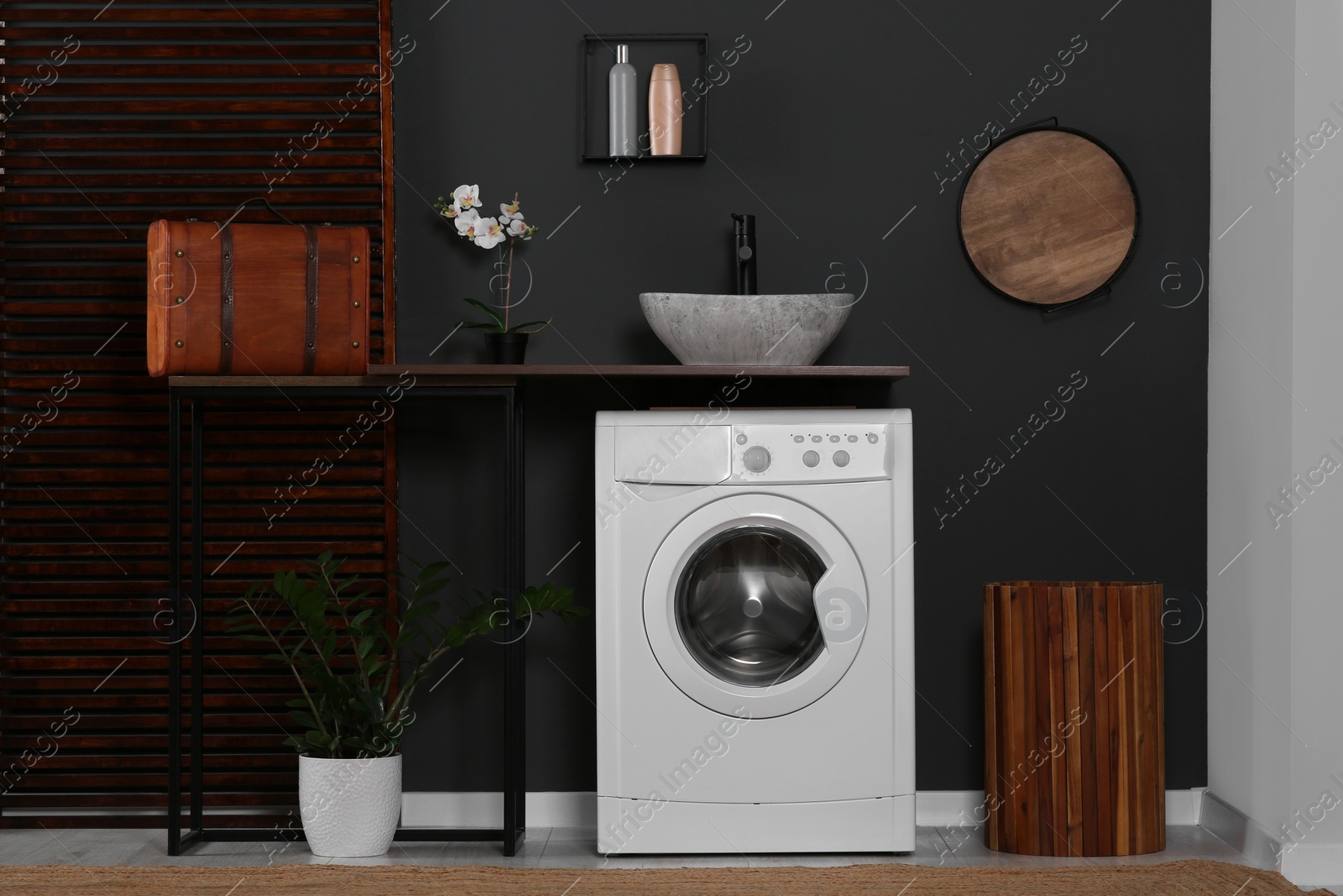 Photo of Stylish laundry room with washing machine. Interior design