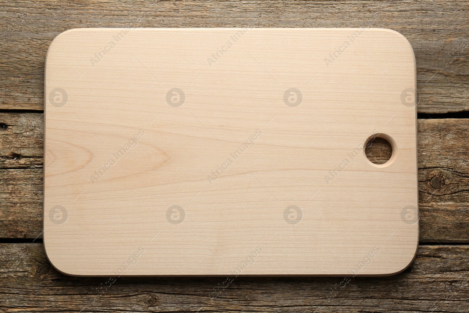 Photo of One new cutting board on old wooden table, top view