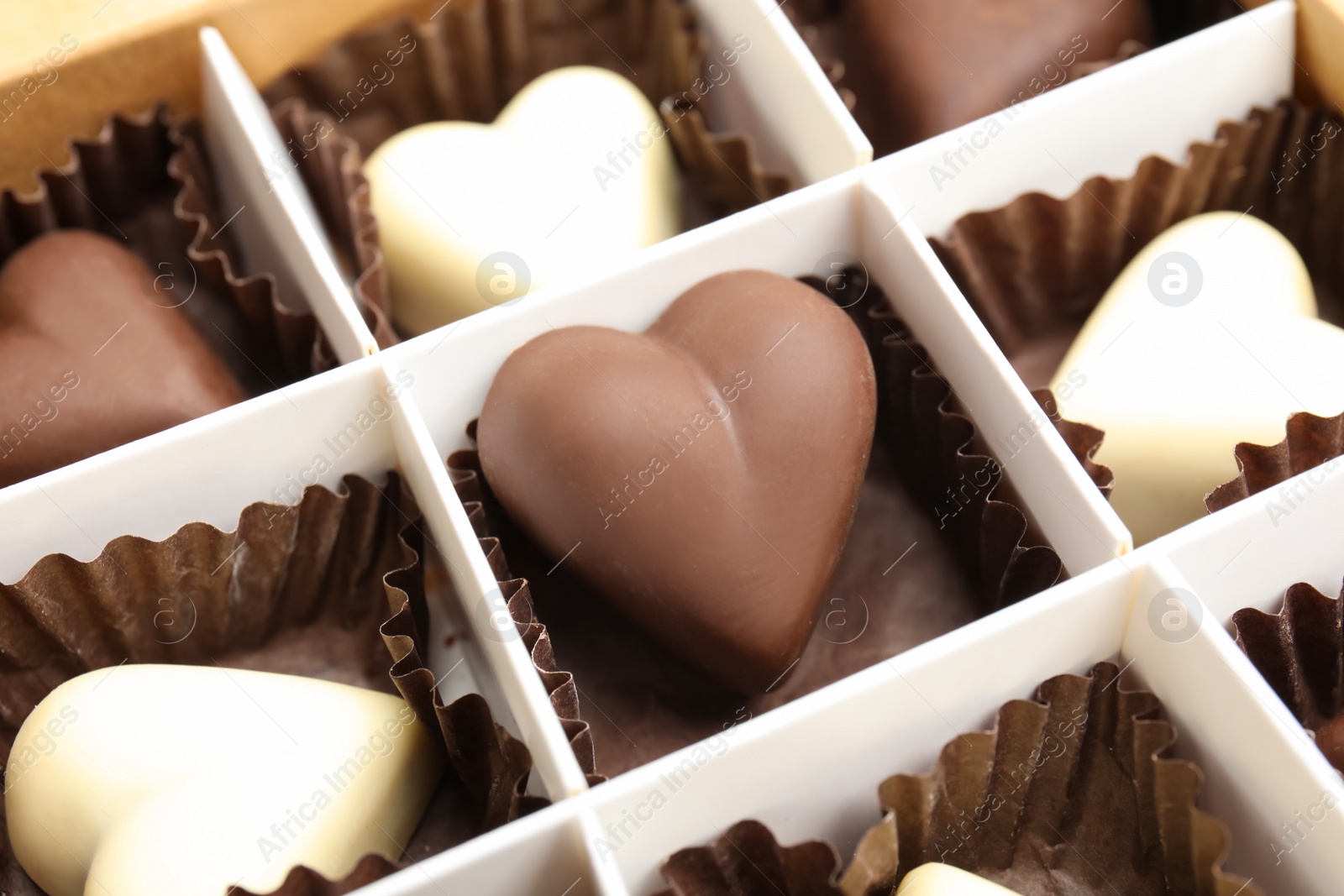 Photo of Tasty heart shaped chocolate candies in box, closeup. Valentine's day celebration