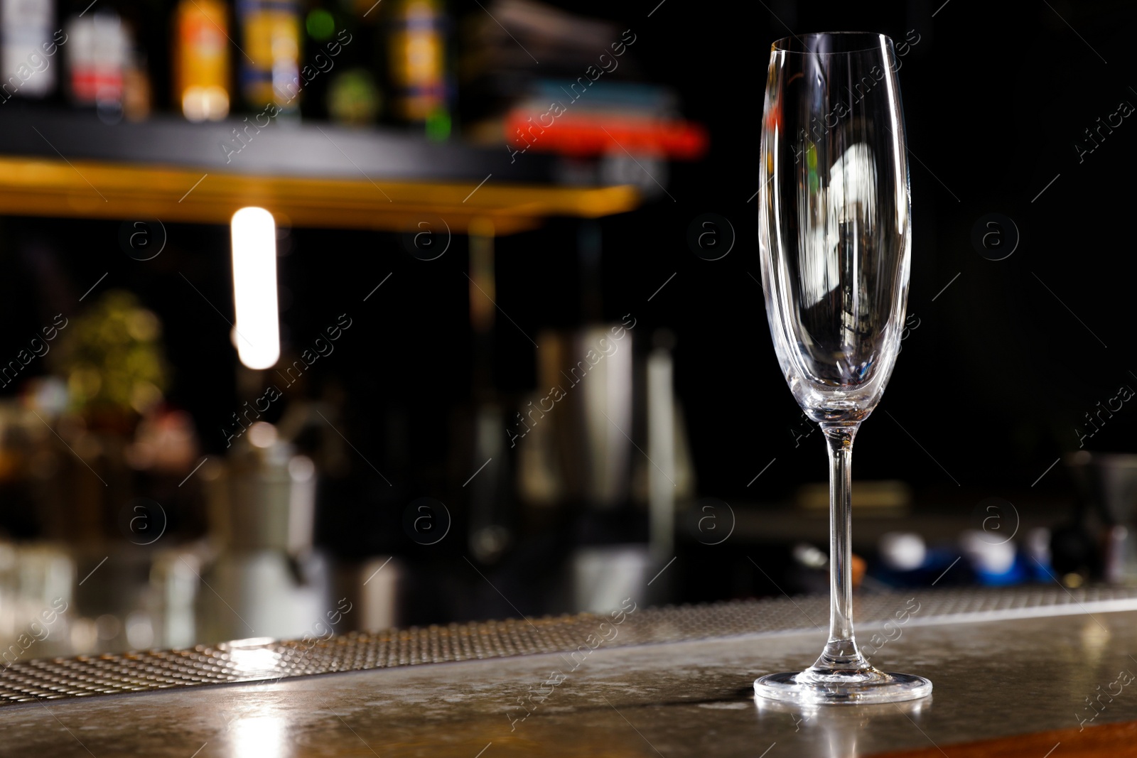 Photo of Empty clean champagne glass on counter in bar. Space for text