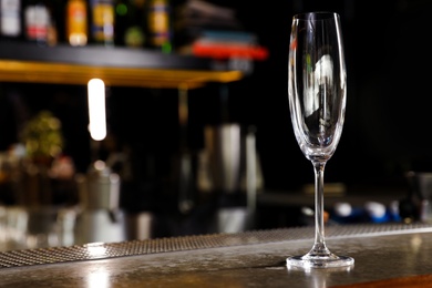 Empty clean champagne glass on counter in bar. Space for text