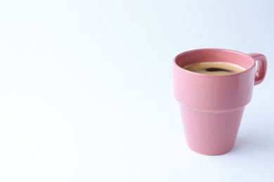 Photo of Pink mug of freshly brewed hot coffee on white background, space for text