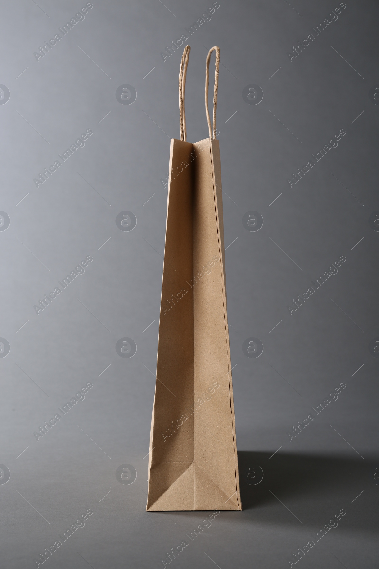 Photo of One kraft paper bag on grey background. Mockup for design