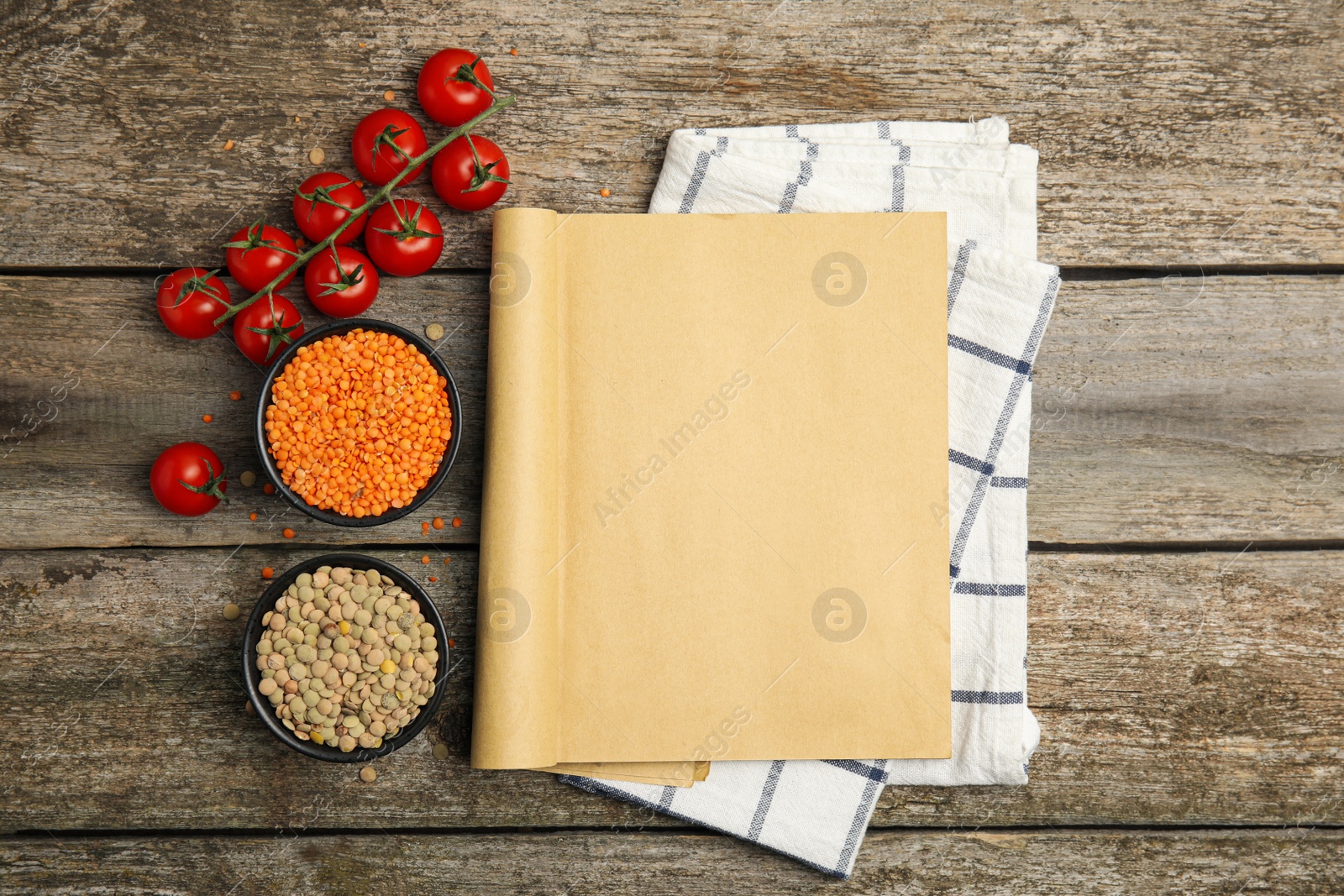 Photo of Recipe book and different ingredients on wooden table, flat lay with space for text. Cooking classes