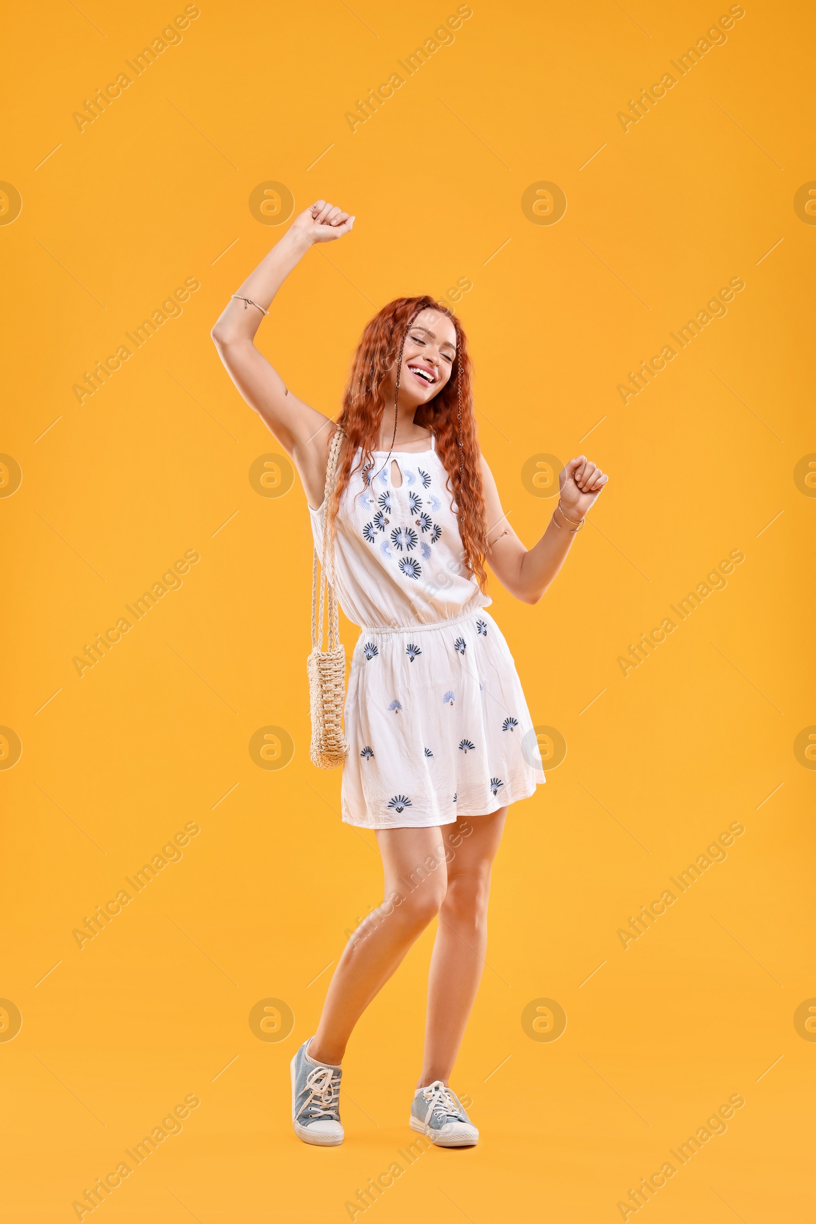 Photo of Beautiful young hippie woman on orange background