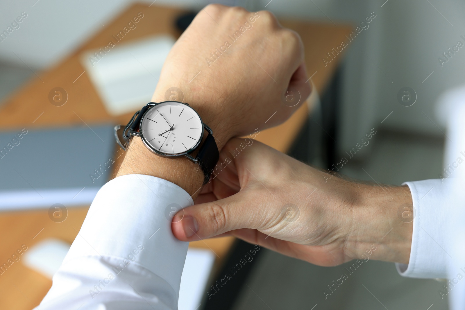 Photo of Man checking time in office, closeup. Being late
