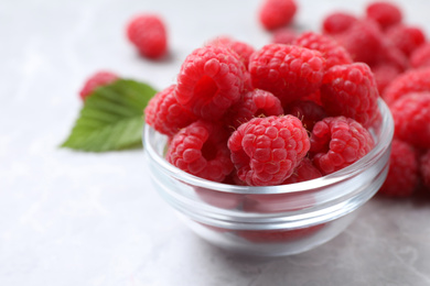 Photo of Delicious fresh ripe raspberries on light grey table, closeup