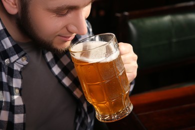 Photo of Man drinking tasty beer in pub, closeup. Space for text