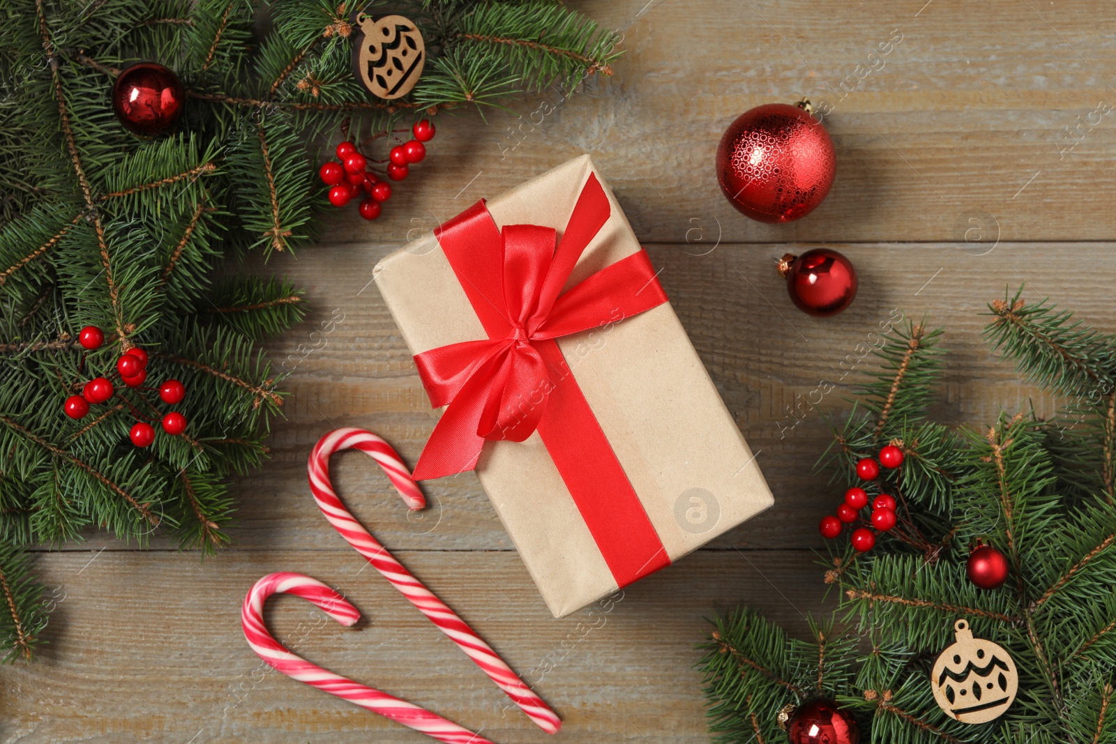 Photo of Flat lay composition with Christmas gift box and decor on wooden table